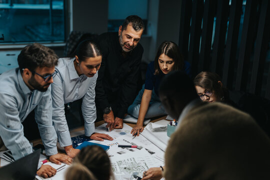 Multiracial team collaborating on creative project in modern office