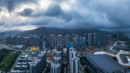 Panoramic view of a dense modern cityscape with numerous residential and commercial buildings under a cloudy sky in Zhuhai.