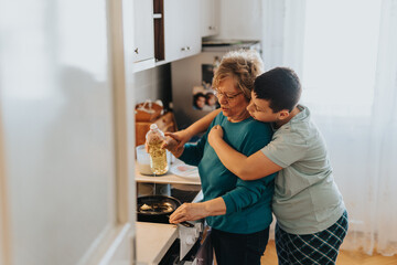 An elderly woman and her grandson bond during a cooking experience in the kitchen, emphasizing the importance of family connections and shared moments. The scene is filled with warmth and affection.