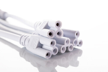 A collection of white connector plugs arranged on a white background. The plugs have multiple ports...
