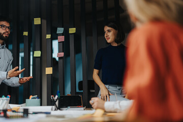 A diverse group of business colleagues working together, discussing ideas and solutions around a...