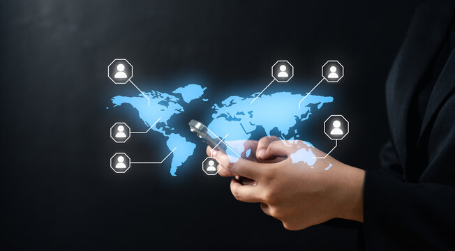 A person uses a smartphone with a digital world map and connected user icons, symbolizing global communication and networking.