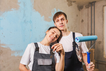 Own home. Mortgage relocation concept. Happy couple holding key from new first house. Family...