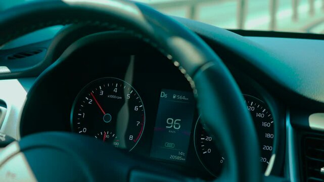 Car speedometer in ECO mode for reduced emissions showing rising speed and current gear. Dashboard indicating fuel range, engine RPM, and temperature. Digital display presenting driving data with