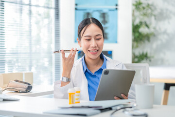 Portrait of an Asian female doctor using a smartphone in a hospital corridor, interacting with a virtual assistant or AI chatbot. She reviews health data via smart mirror technology, embracing future
