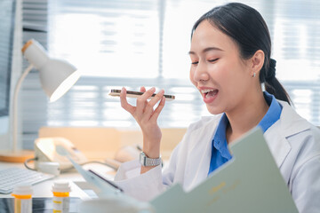 Portrait of an Asian female doctor using a smartphone in a hospital corridor, interacting with a virtual assistant or AI chatbot. She reviews health data via smart mirror technology, embracing future