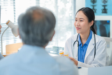 Asian doctor in uniform attentively assists a senior couple with medical paperwork in a hospital area, explaining health records and test results with care and professionalis senior health