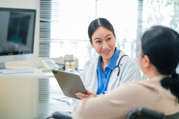 experienced female medical professional explains test results to a female patient during a clinic consultation. reviewing reports and discussing diagnosis and treatment options.compassionate care
