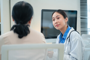 experienced female medical professional explains test results to a female patient during a clinic consultation. reviewing reports and discussing diagnosis and treatment options.compassionate care