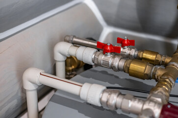 Technician plumber using a wrench to repair a water pipe under the sink. Concept of maintenance,...