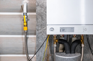 Concept of modern appliance. Side view of new white water heater at the kitchen closet, copy space....
