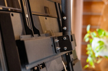 Swivel TV bracket LED display. Side view. X-shaped red fasteners. Black color. Multiplanar. Hangs...