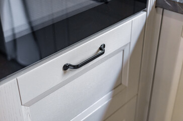 Angled shot of White Cabinets with Black Handles and a Marble Countertop