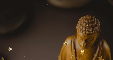 Shining carved Buddha statue radiating warm glow on display, with star-shaped confetti, copy space
