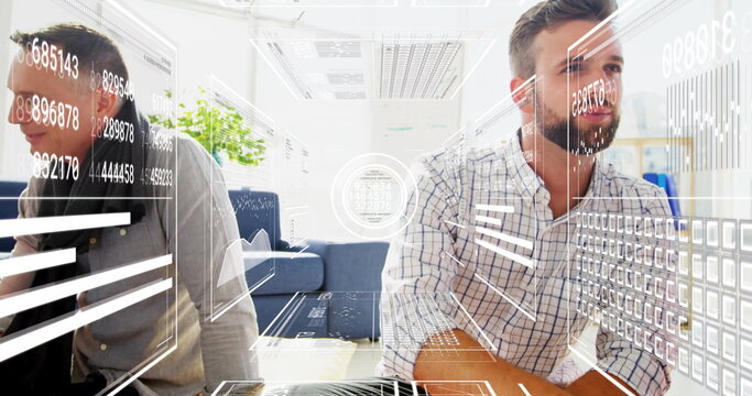 Sitting bearded man in checked shirt reviewing chart overlays at office lounge, with potted plant - Powered by Adobe