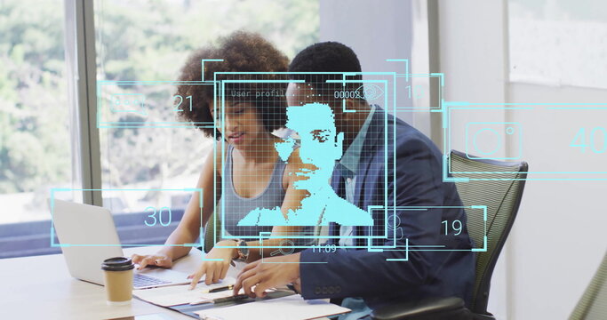 Colleagues analyzing documents and holographic overlays in office meeting room, with laptop