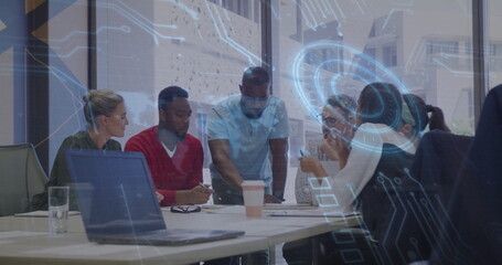 Six colleagues collaborating around long white table in modern office, with laptops and coffee cups