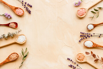 Obraz na płótnie Canvas Beauty spa therapy cosmetics and wellness flat lay - sea salt in many spoons with flowers, top view