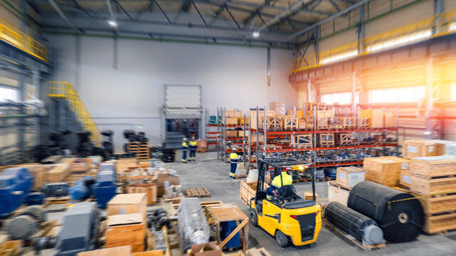Warehouse industrial premises for storing materials of mining, forklift for containers. Concept banner logistics, transport. Motion blur effect, bright sunlight