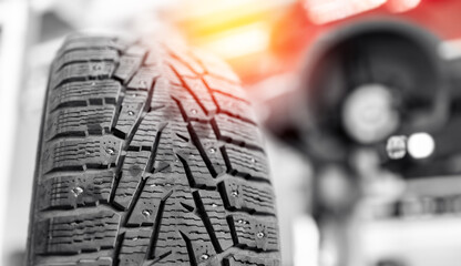 Close-up of winter tire tread during car maintenance at auto service, sunlight