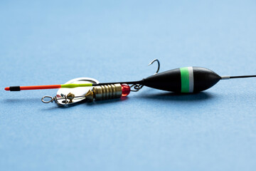 Fishing tackle including a lure, float, and hook on a blue background. 