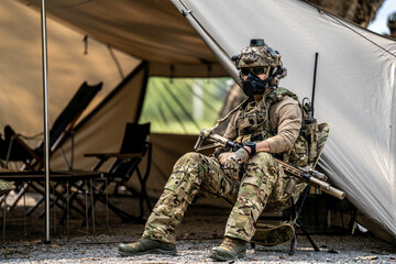 Elite Special Forces Soldier in Tactical Gear Preparing Weapon – Combat Mission Readiness Near...