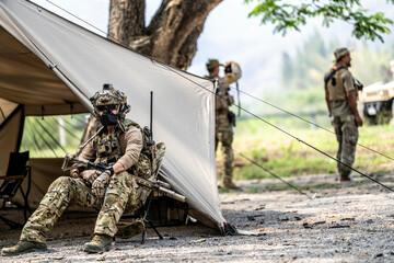 Elite Special Forces Soldier in Tactical Gear Preparing Weapon – Combat Mission Readiness Near...
