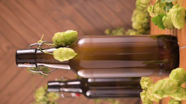 Macro shot of a cold brown beer bottle with a droplet of condensation slowly sliding down. Fresh green hops decorate the bottle. Symbol of refreshment, thirst, and artisanal brewing. High 4k footage