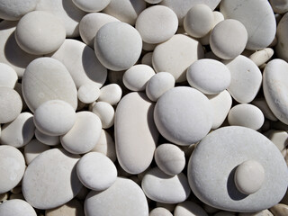 Macro shot of small white round pebbles, perfect as zen-inspired texture or design element.