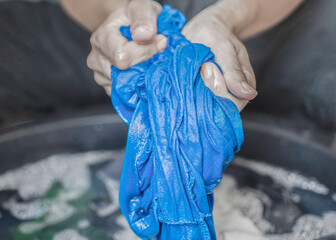 Washing clothes by hand in the traditional way without using a machine.