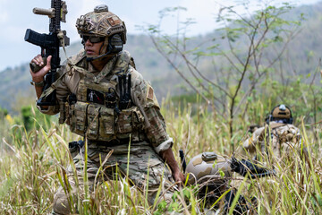 Special forces soldier holding rifle and communicating on radio during tactical operation in...