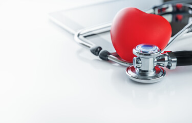 Red heart with doctor stethoscope and tablet on white background. Healthcare, heart checkup, health, blood donor month and technology concept. Copy space.