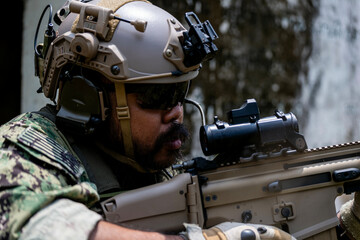 Special forces soldier holding rifle and communicating on radio during tactical operation in...
