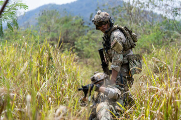 Special forces soldier holding rifle and communicating on radio during tactical operation in...