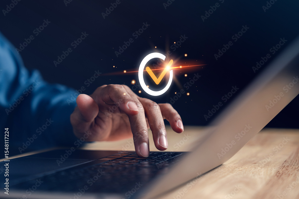 Poster Close-up hand typing on laptop with  check mark symbolizing quality assurance, guarantee, approval, and secure validation process in modern digital and business platforms.