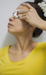 A female person is shown wiping, mopping, or rubbing clean using a cloth to clean the skin on the face and body.