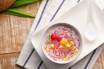 Thai iced dessert (Ruam Mit),Popular Thai Fruit Dessert in Coconut Milk in white bowl.Top view.copy space.