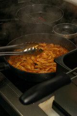 Chef cooking classic Italian linguine Bolognese in a professional restaurant kitchen – authentic cuisine, fresh ingredients, culinary art in action.