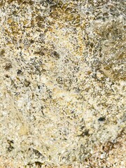 Old weathered brown and yellow grunge stone wall texture with natural rough rock and sand patterns