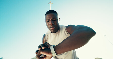 Black man, runner and smart watch in city for fitness, stats and break with low angle for training....