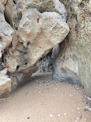 Coastal Cave Entrance: Explore a natural coastal cave carved by the elements, revealing a sandy...