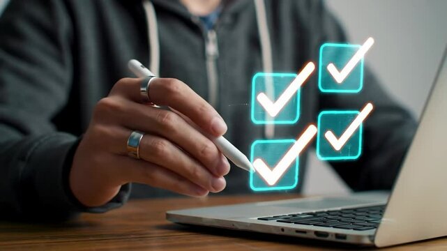Digital productivity and efficient task completion using modern technology. Hand marking digital checklist boxes on a laptop screen with stylus.