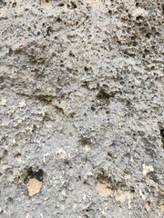 Old gray stone wall with rough abstract texture