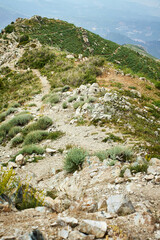 Close-up of a narrow, rocky mountain trail on the west ridge, leading to Big Chimgan peak. Details of the ground and sparse vegetation are visible, typical for a pre-summit section