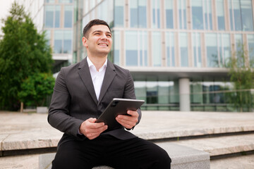 Business professional enjoys a moment of relaxation while using a tablet in a modern urban setting...