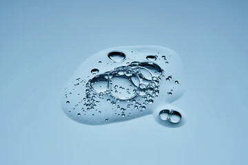 Delicious serum texture with bubbles on a blue background.