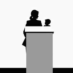 Woman speaking at podium with child beside her

