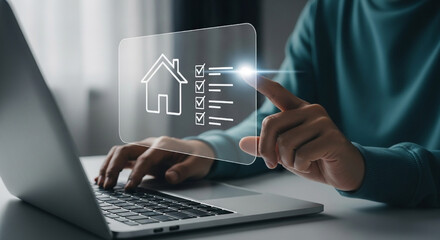Person interacting with a laptop screen depicting a house icon and checklist indicating property approval or successful transaction.