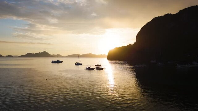 Vibrant Tropical Sunset with Silhouettes of bangka boats at El Nido, Corong Corong Beach, Palawan, Philippines.