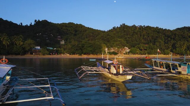 Bangka boats resting in Clear Skies and Peaceful Blue Horizon Over Coastal Paradise of El Nido&rsquo;s Corong Corong Beach